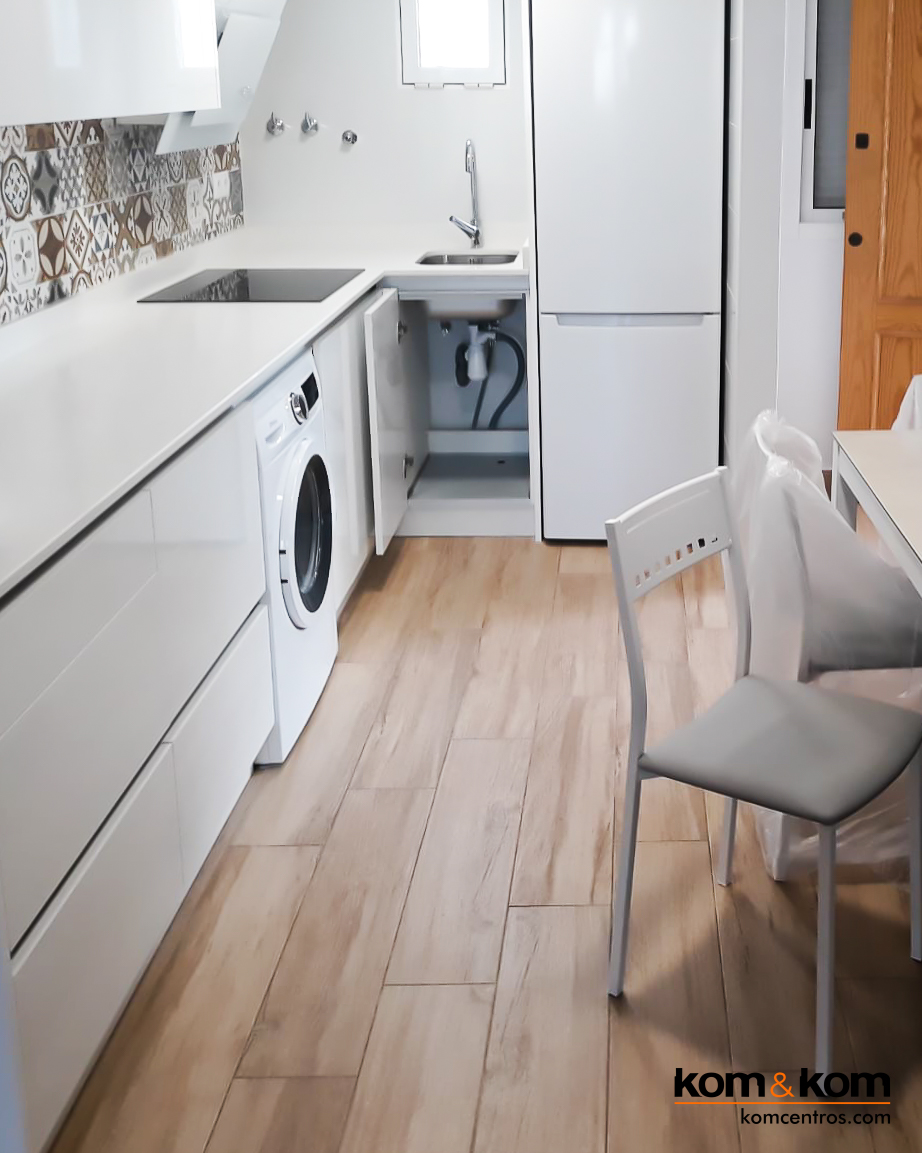Cocina total white abierta al salón. Suelo estilo madera y azulejos tipo hidráulico.